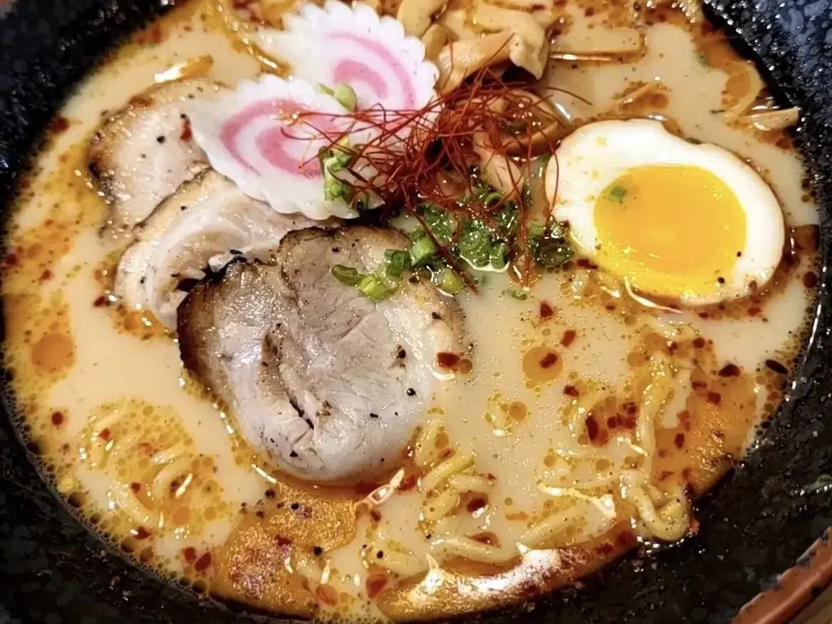 Creamy tonkotsu ramen with chashu pork, soft egg, fish cake and red chili threads