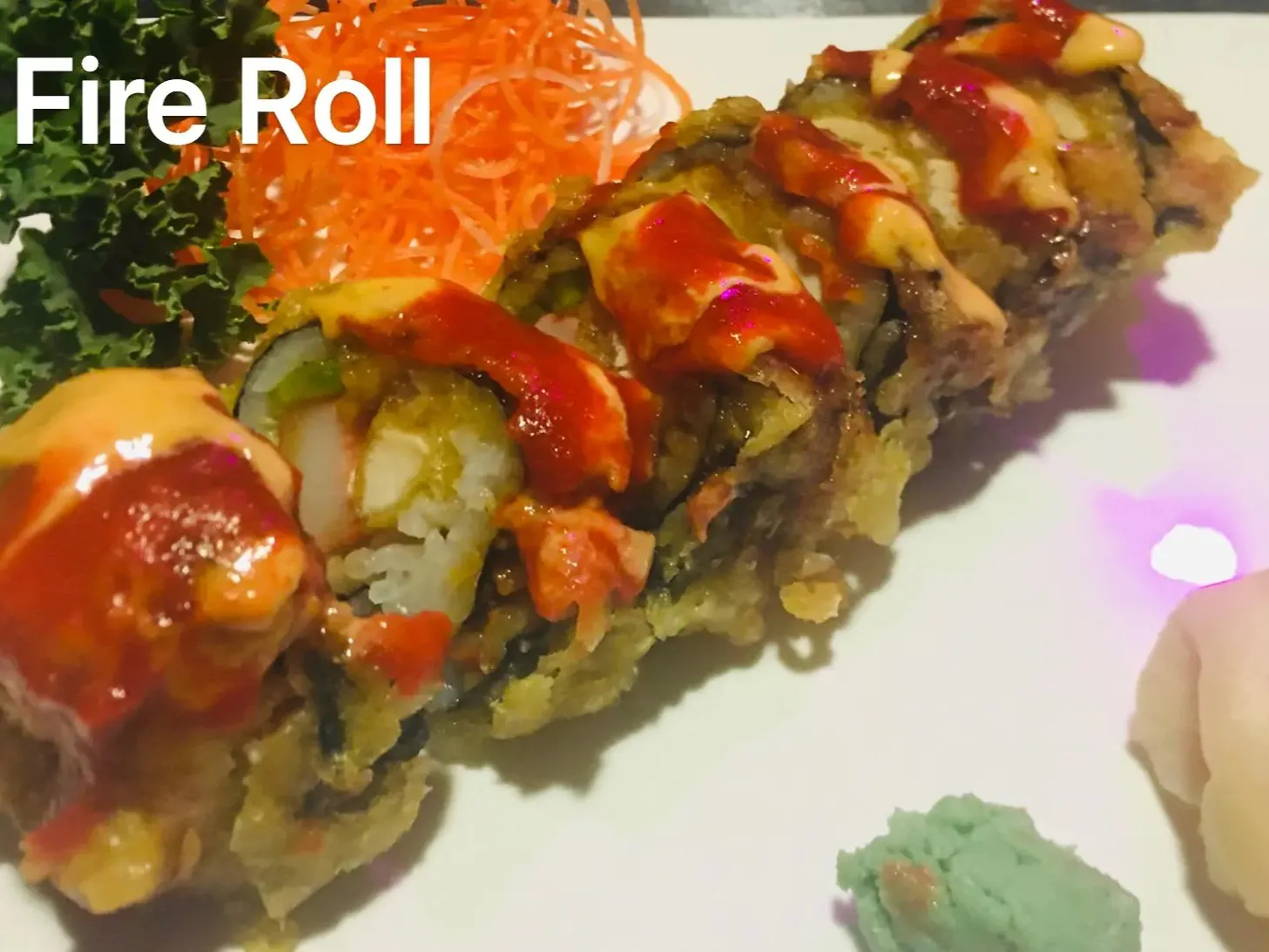 Crispy fried Fire Roll sushi with spicy red and creamy yellow sauce on white plate